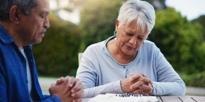 Old couple praying, planning